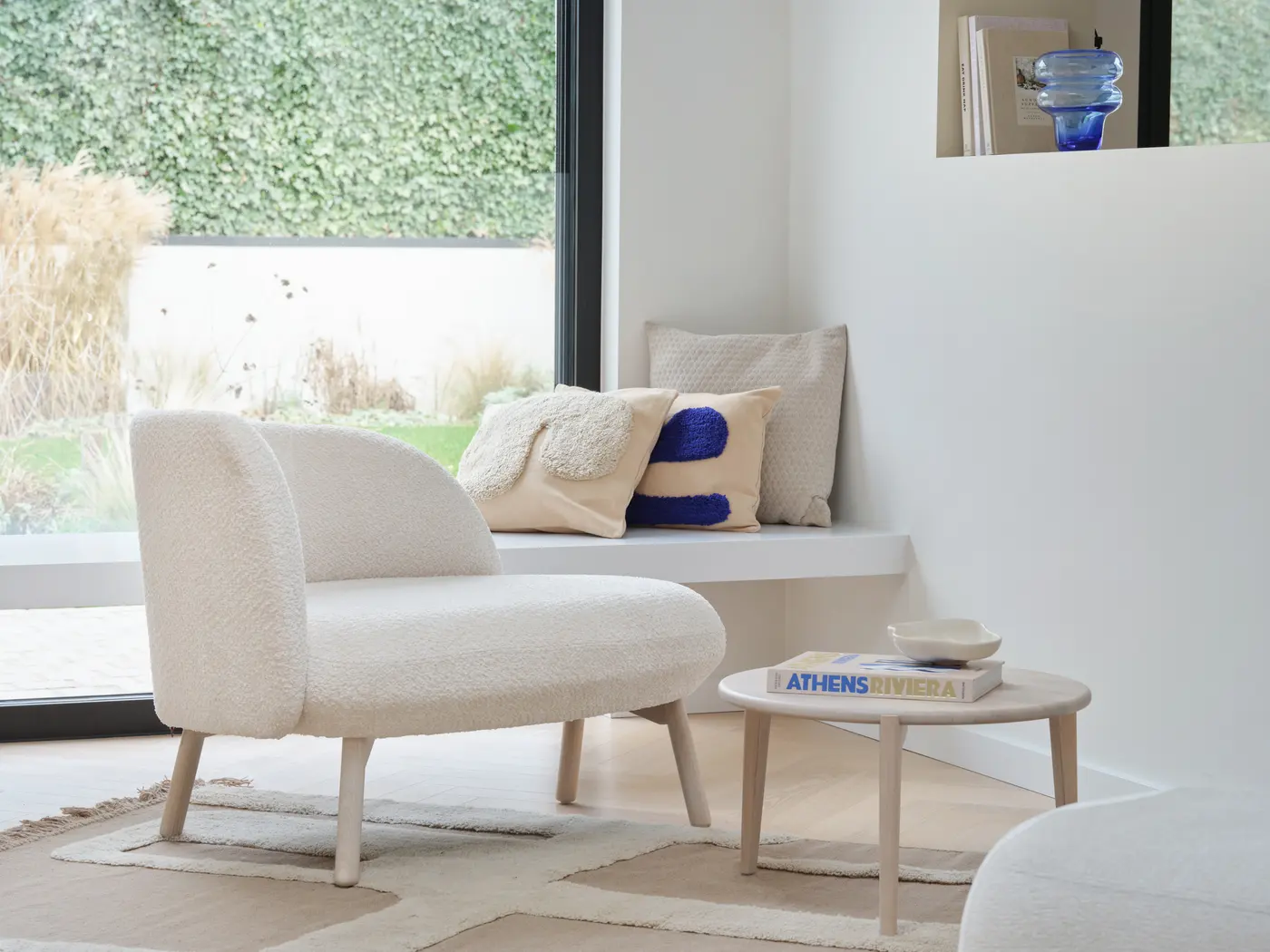 Banquette sous une grande fenêtre, table basse en bois.
