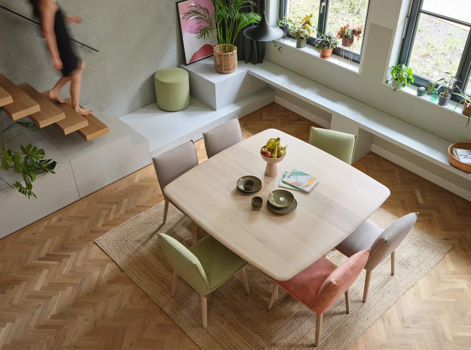 Table dressée dans une pièce de vie, bois et textile.