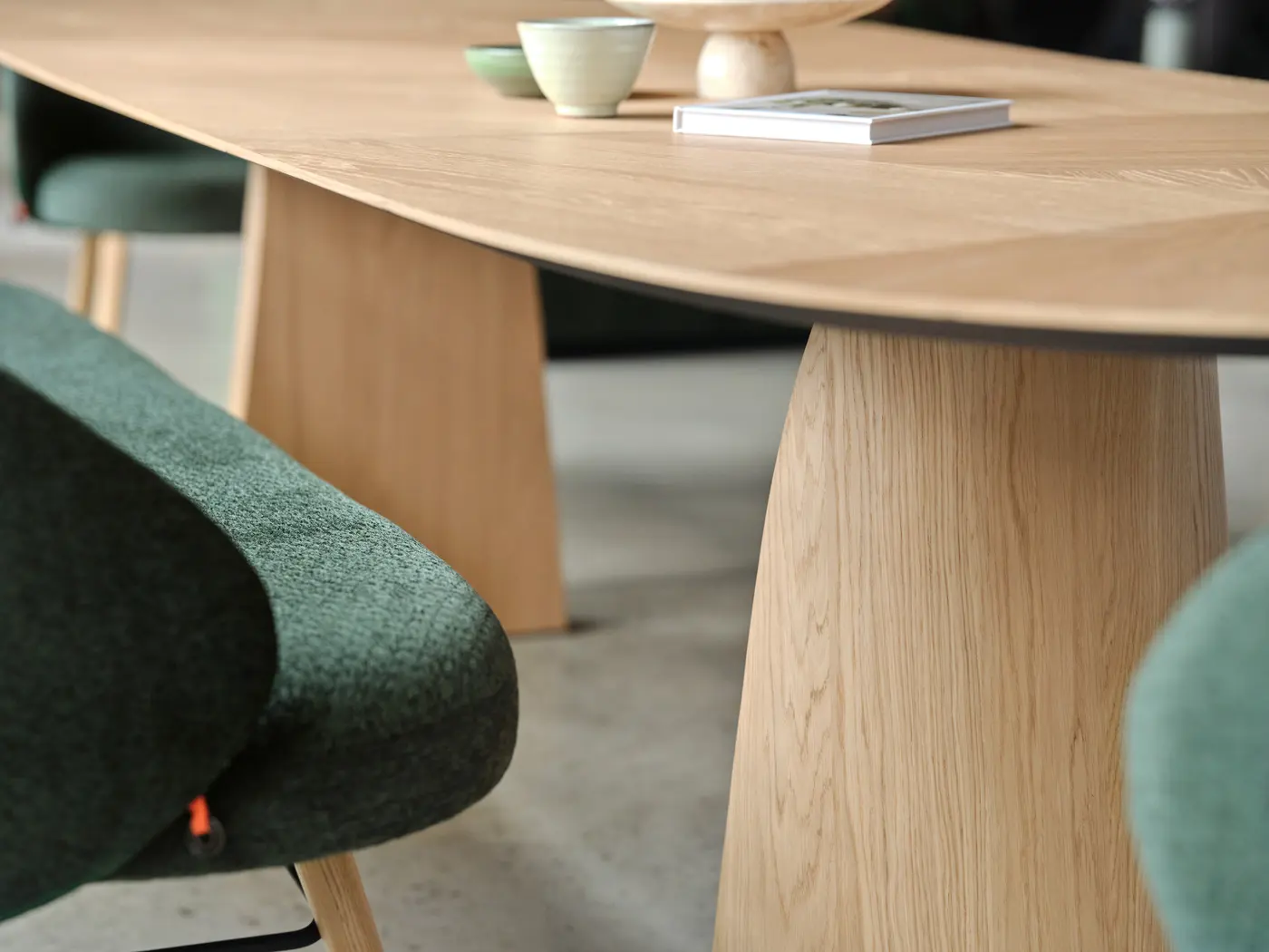 Plateau arrondi en bois clair et assise verte.