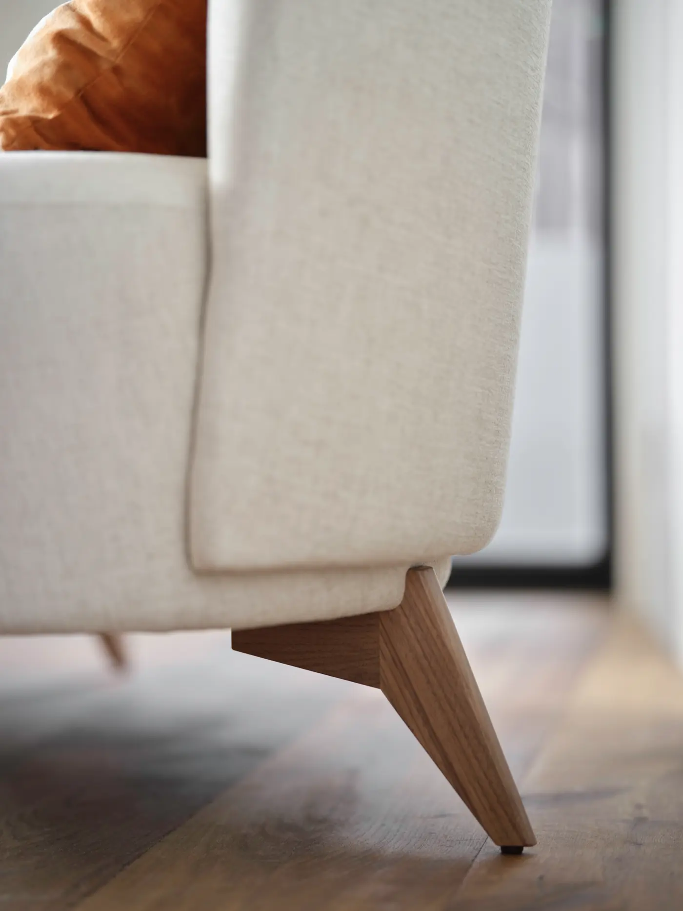 Fauteuil en textile clair, pieds en bois.