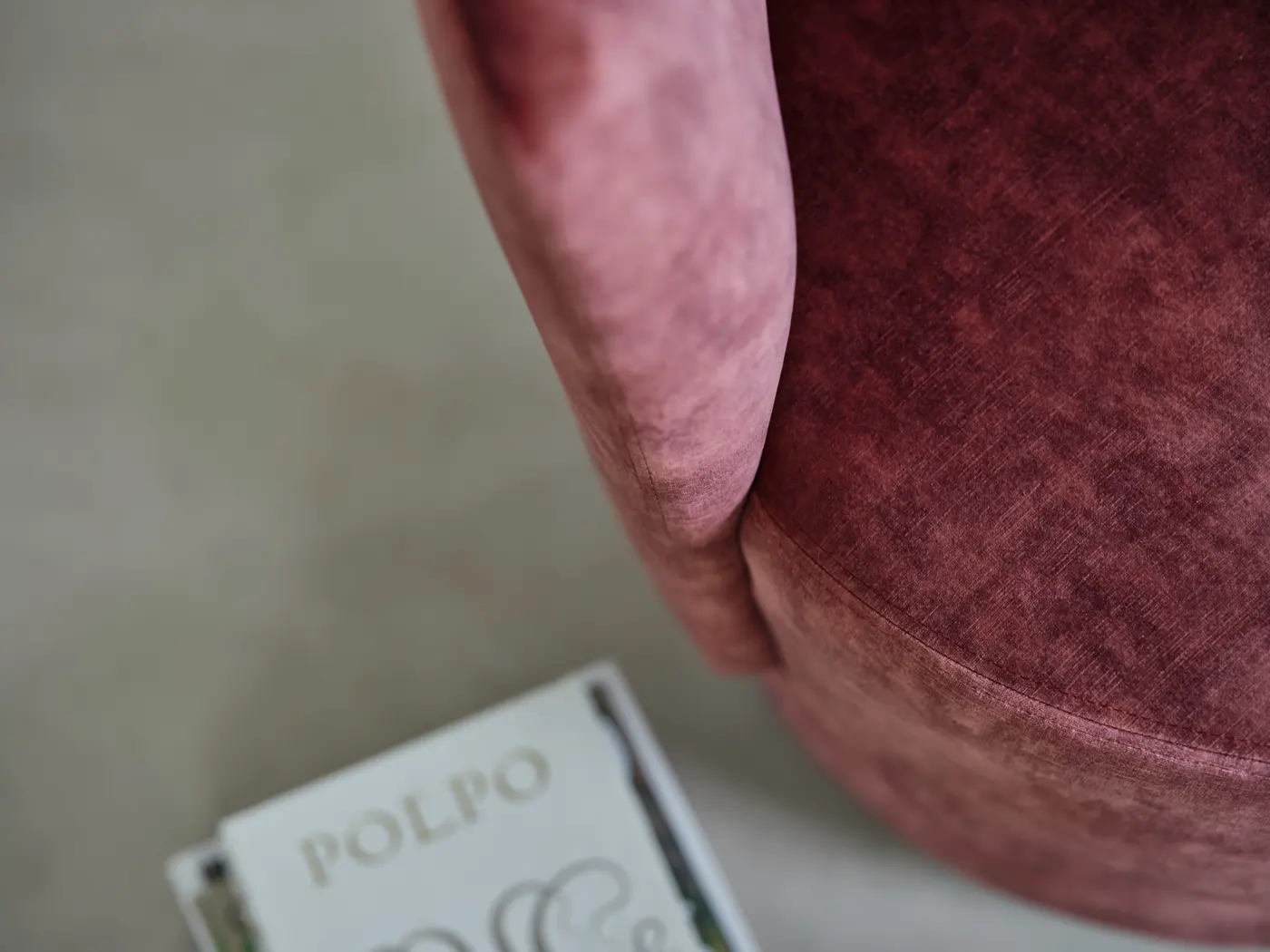 Courbe d’un textile rose, livre posé devant.