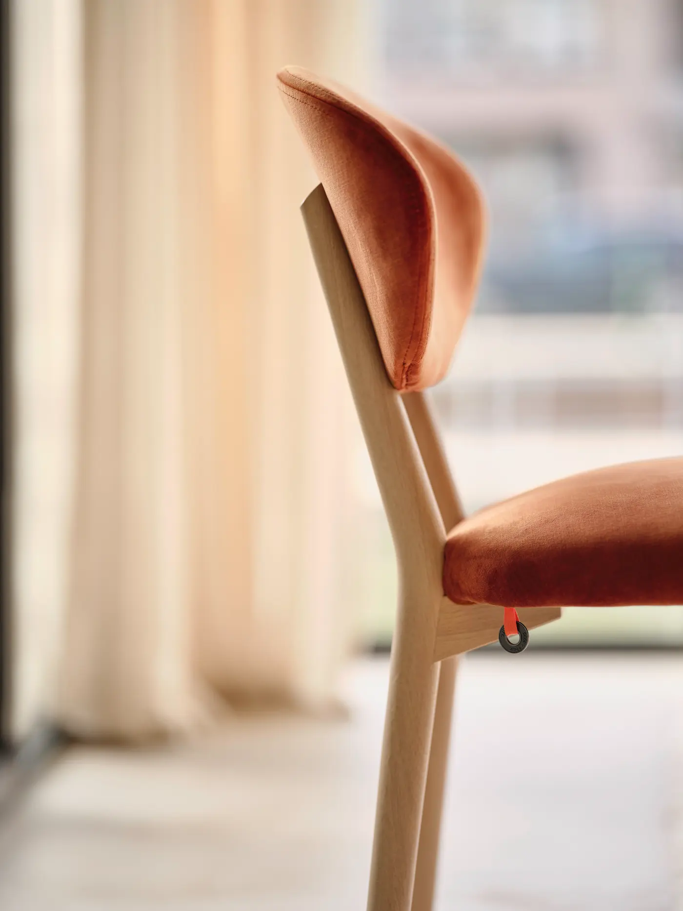 Dossier en textile orangé et cadre en bois.
