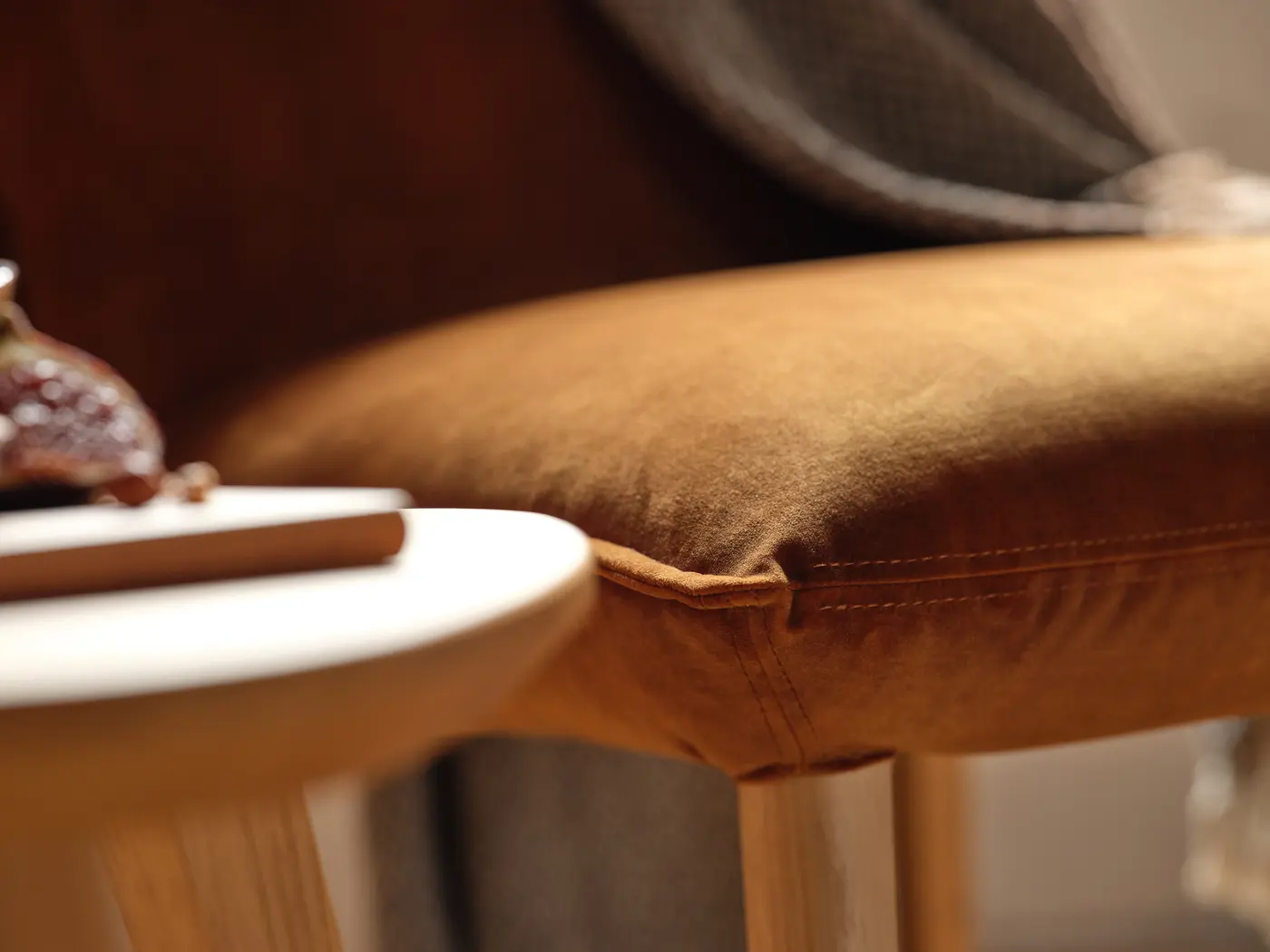 Coussin ocre et plateau en bois.